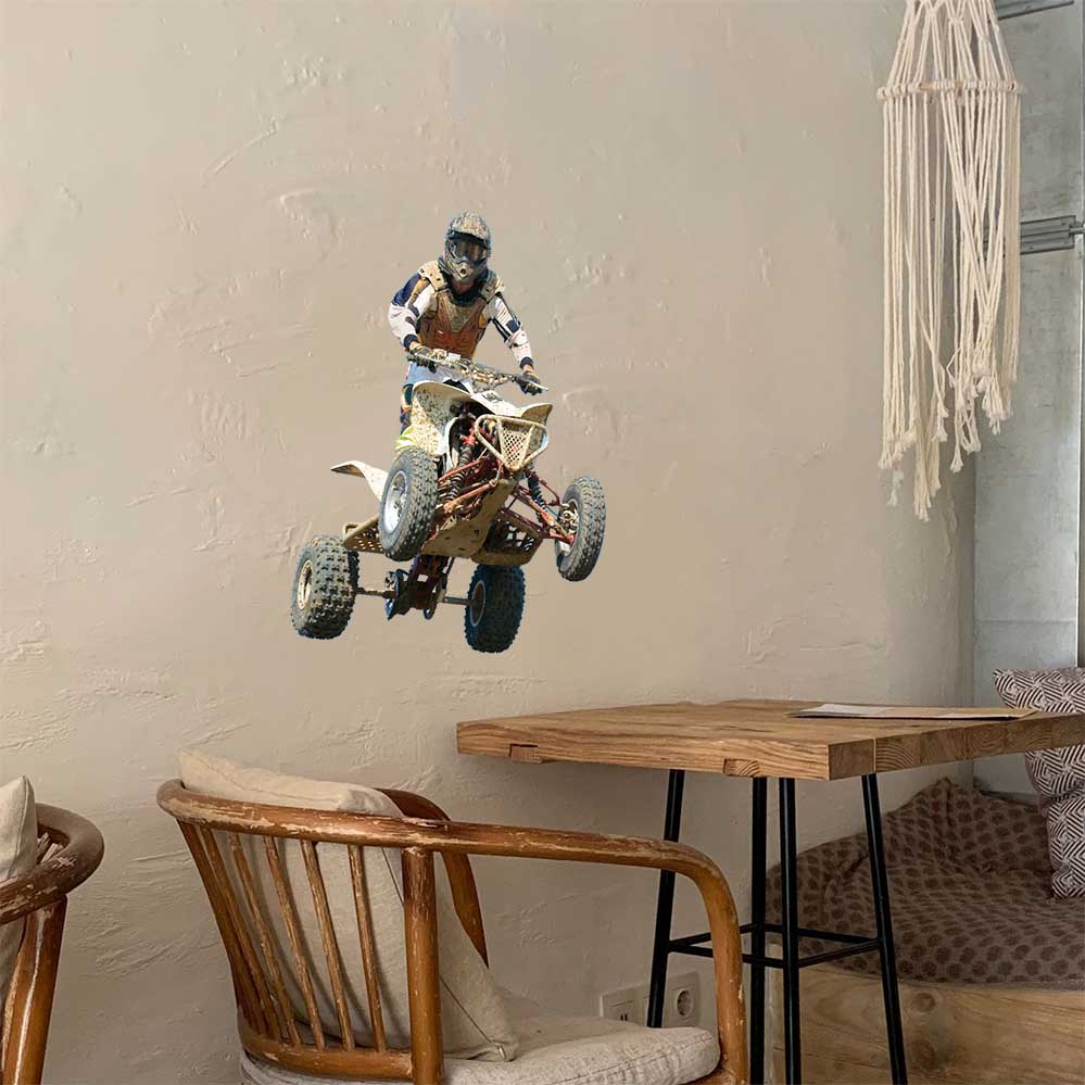 24 inch wall decal of a person jumping a four-wheeler installed on wall above table and chair