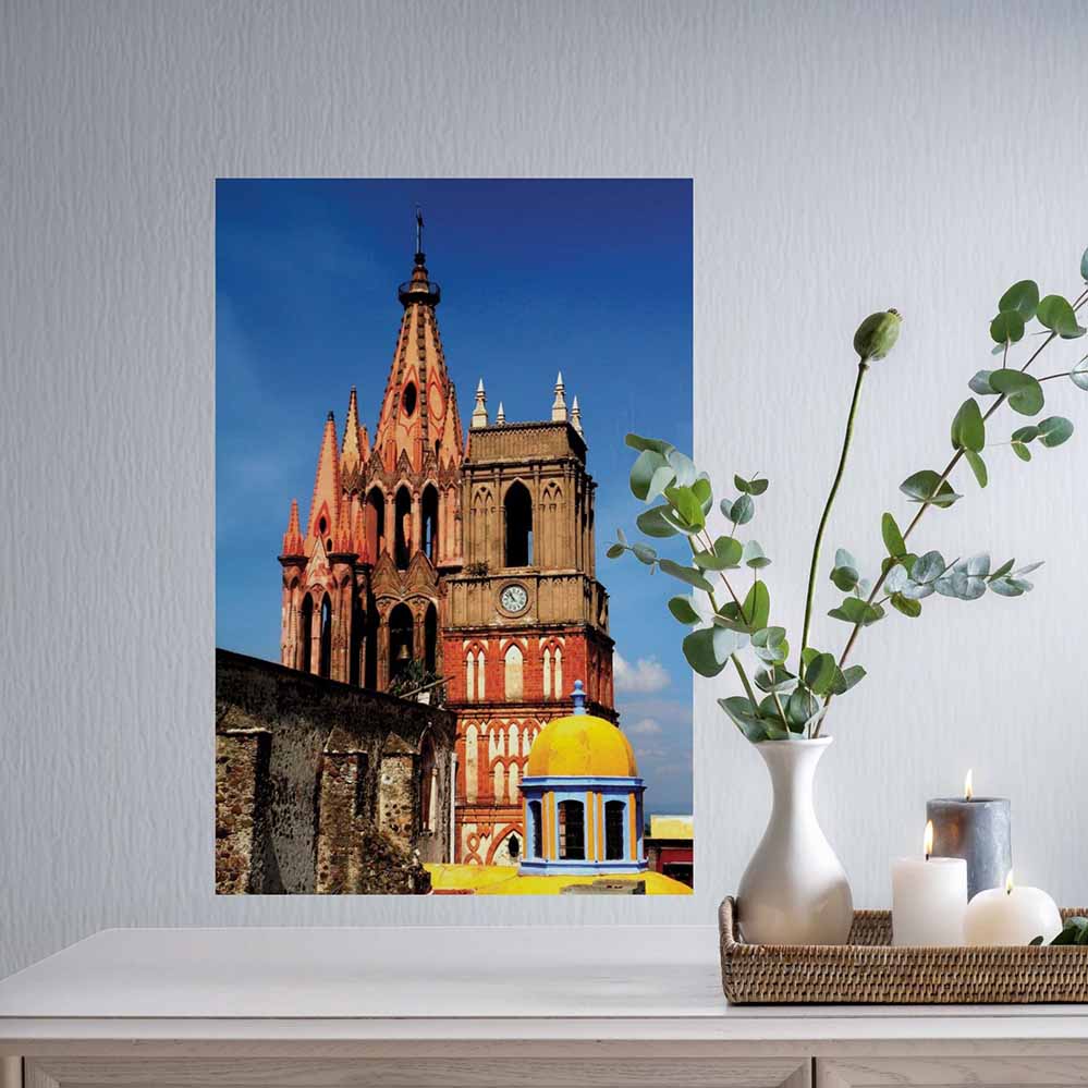 24 inch decal of a Mexican cathedral on installed on a wall above a decorative table with candles and a vase.