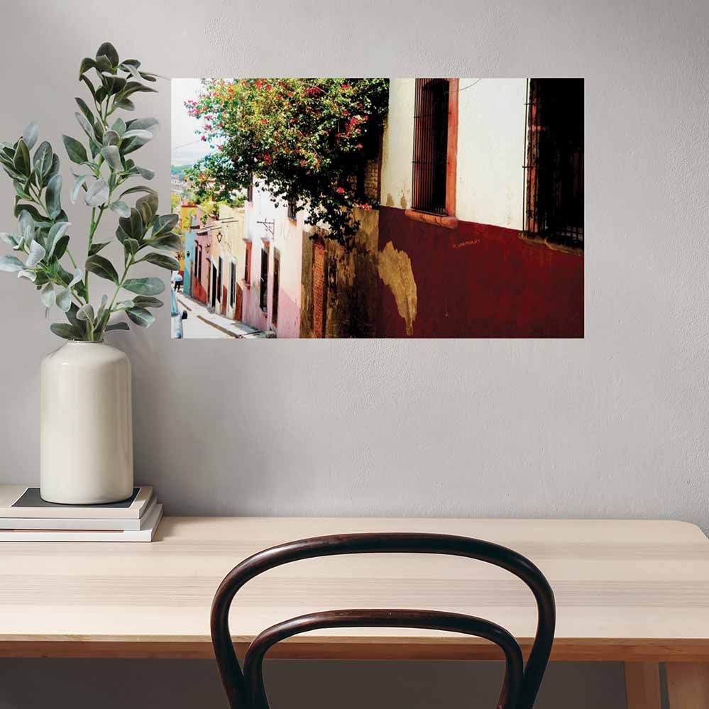 24 inch wall decal of Mexican street homes with floral bushes installed on a wall above desk