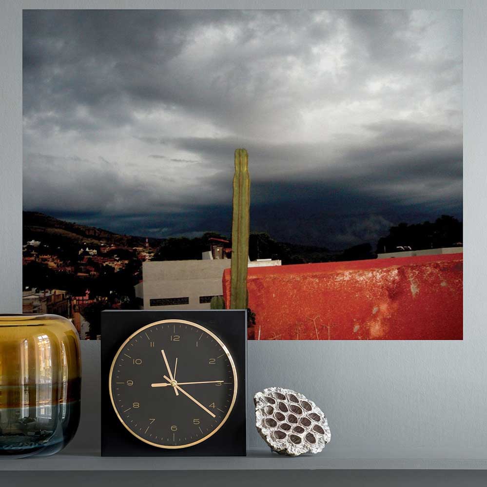 24 inch Mexican storm brewing with cactus in foreground decal installed on wall above clock and vase on counter