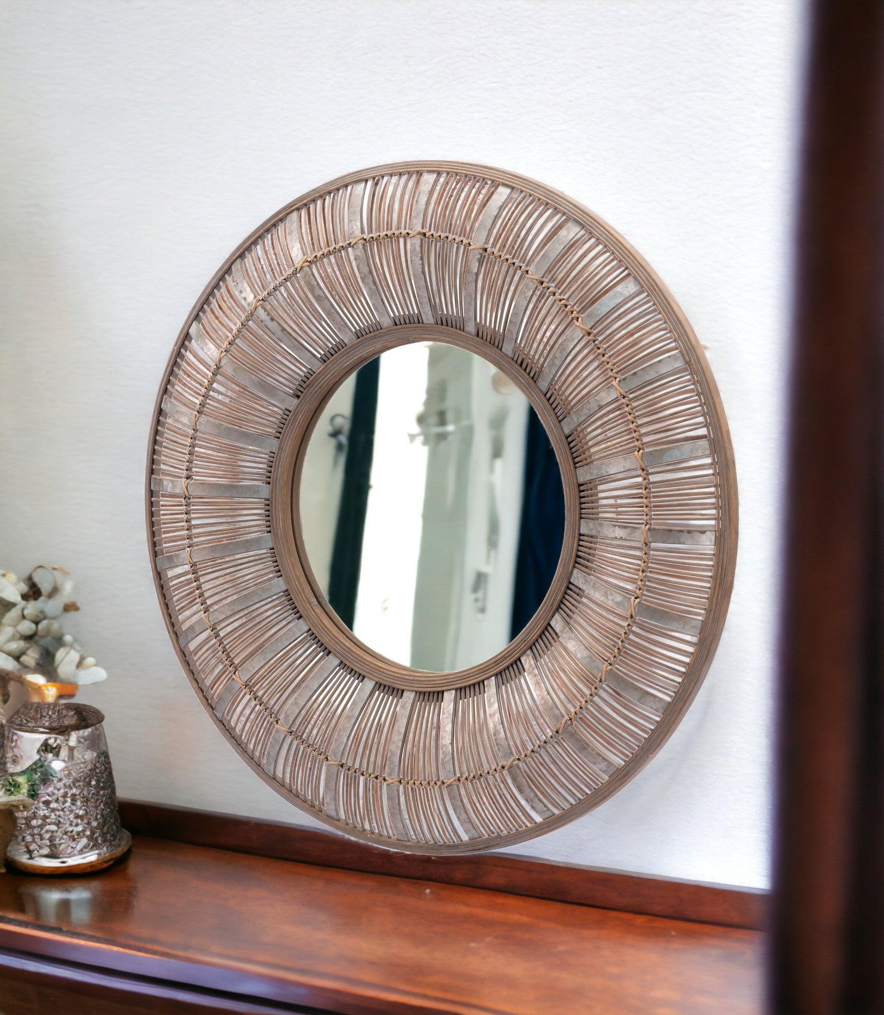 32 inch Brown Rattan Round Accent Wall Mirror Sitting on Shelf