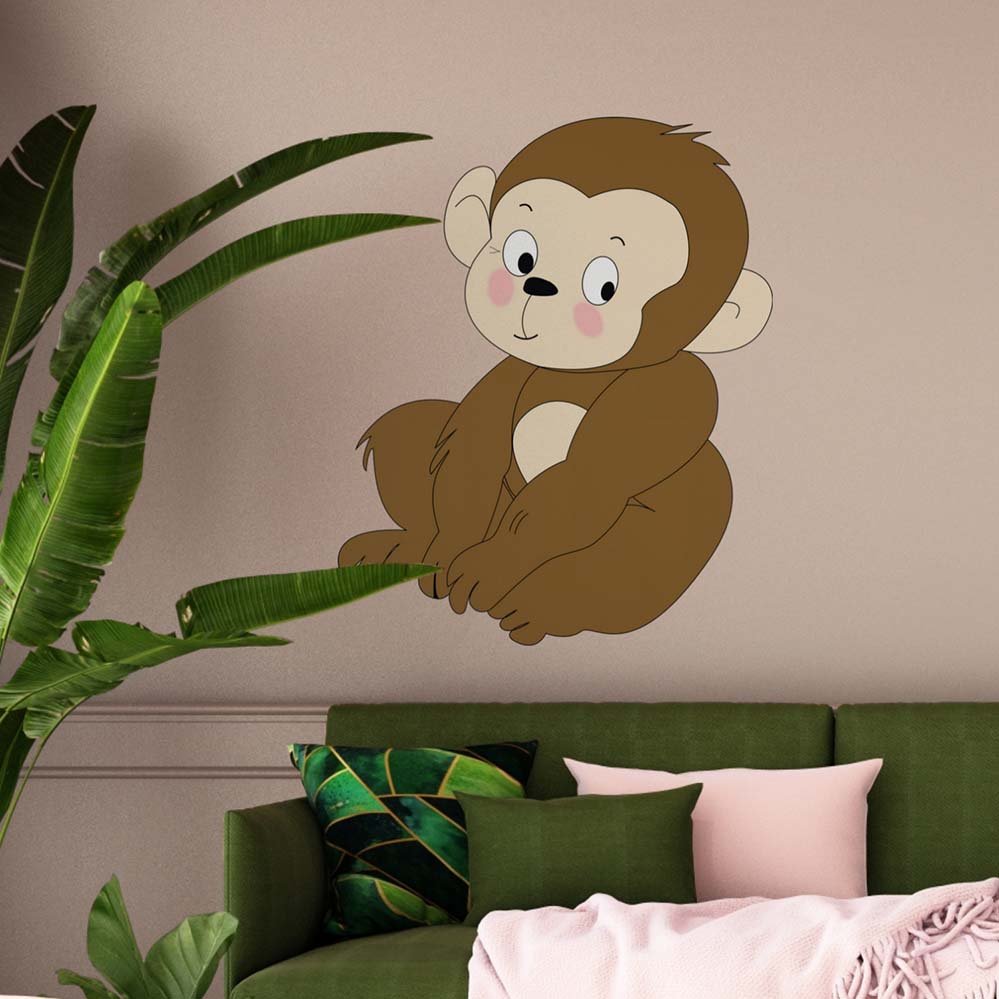 36 inch Baby Monkey cartoon wall decal installed on a wall above a green couch with pink and green pillows.