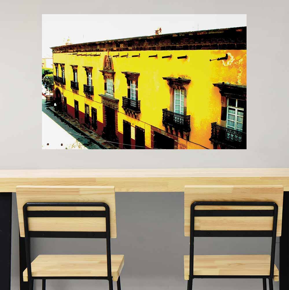 36 inch decal of yellow Mexican hotel with balconies installed on a wall above a counter and chairs