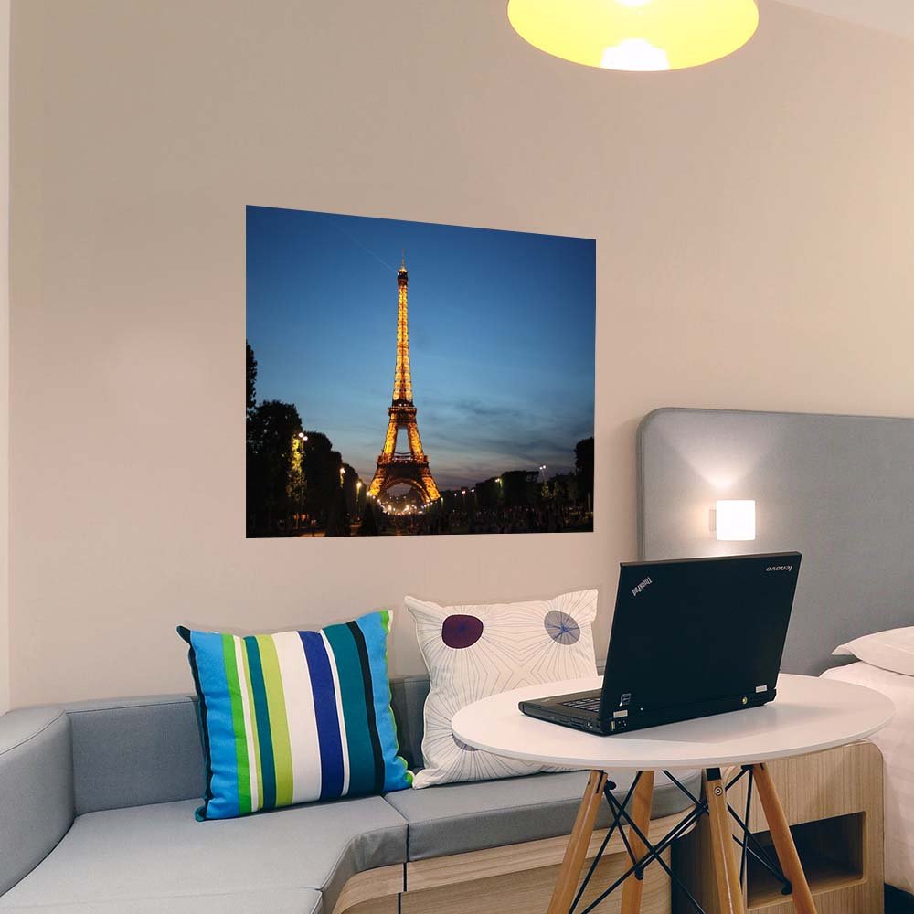 36 inch poster of the Eiffel Tower illuminated at dusk displayed on a wall above a bench seat in a bedroom