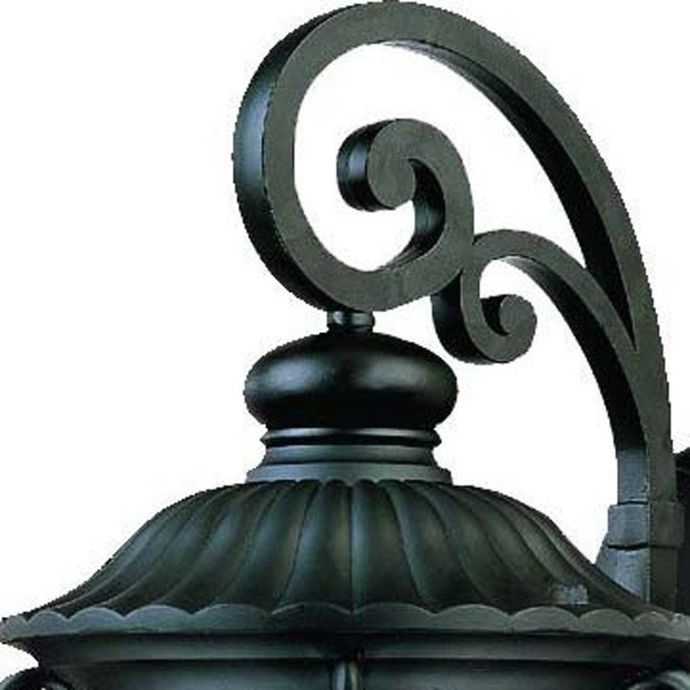 Zoomed in view of the scroll arm and top frame of the Naples 3-Bulb Matte Black Outdoor Hanging Wall Light with Seeded Glass and Italian Scroll Design