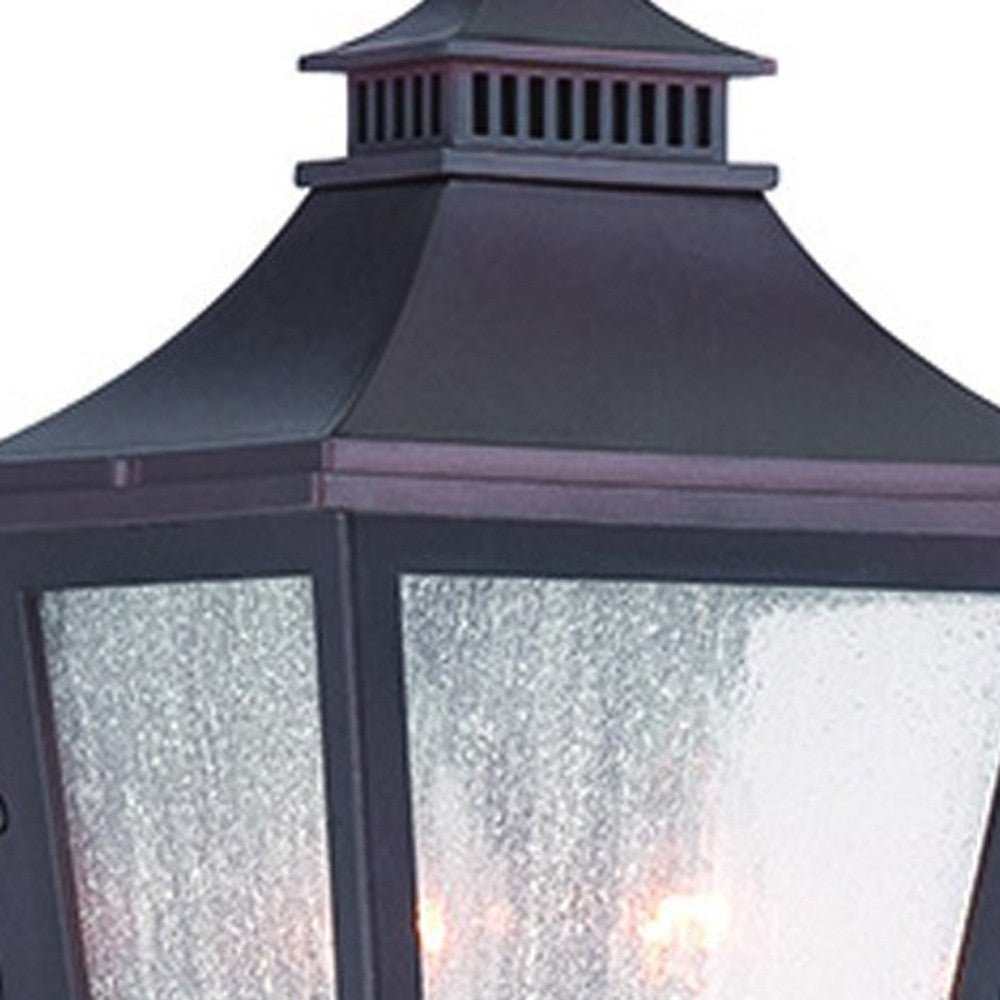 Close up view of the lantern top and glass shade of the lighted Antique Bronze Two Light Outdoor Pocket Lantern Wall Light with Frosted Glass