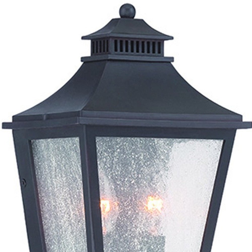 Zoomed in view of the top half of the lighted Matte Black Two Light Outdoor Pocket Lantern Wall Light with Frosted Glass
