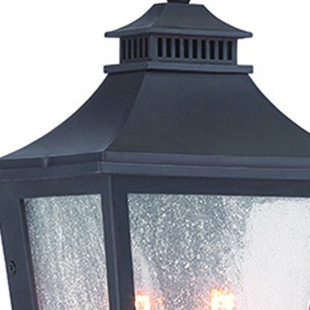 Close up view of the lantern top and glass shade of the lighted Matte Black Two Light Outdoor Pocket Lantern Wall Light with Frosted Glass