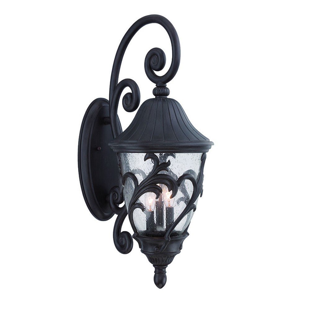 Front left view of the lighted Three Light Matte Black Leaf Detail Outdoor Wall Fixture with Seeded Glass and Scroll Arm