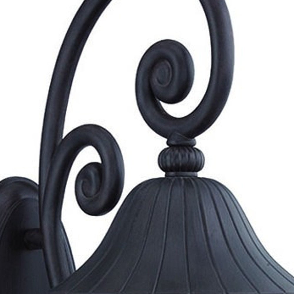 Zoomed in view of the scroll arm and lantern top of the lighted Three Light Matte Black Leaf Detail Outdoor Wall Fixture with Seeded Glass and Scroll Arm