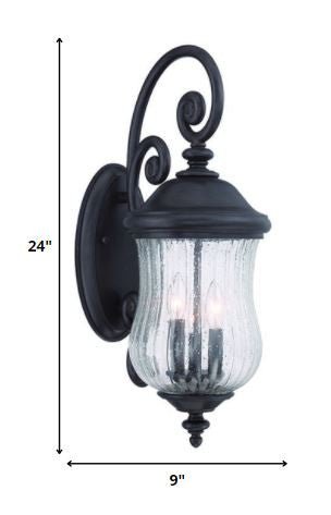 Three Light Matte Black Urn Outdoor Wall Lantern with Raindrop Glass and Spiral Arm shown with dimensions of 24 inches high by 9 inches wide