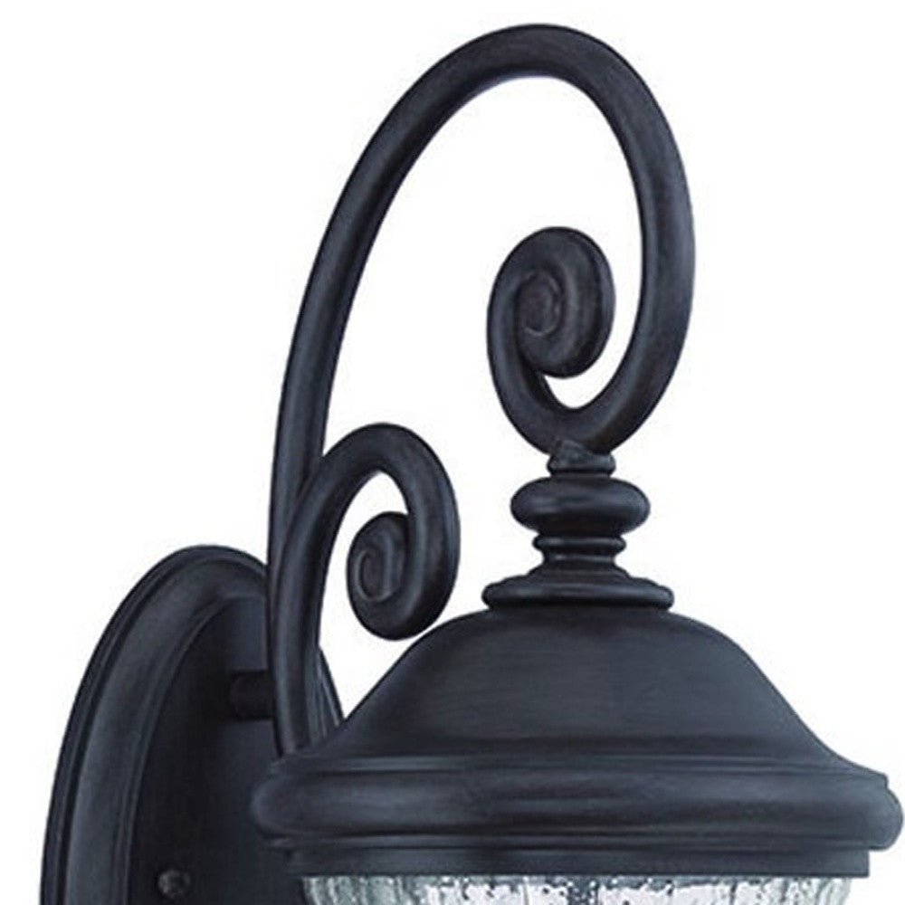 Zoomed in view of the wall plate and scroll arms of the Three Light Matte Black Urn Outdoor Wall Lantern with Raindrop Glass and Spiral Arm