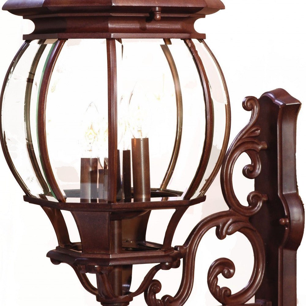Zoomed in view of the framework and glass globe of the lighted Chateau 4-Bulb Burled Walnut Outdoor Wall Lantern with Scrollwork and Beveled Glass