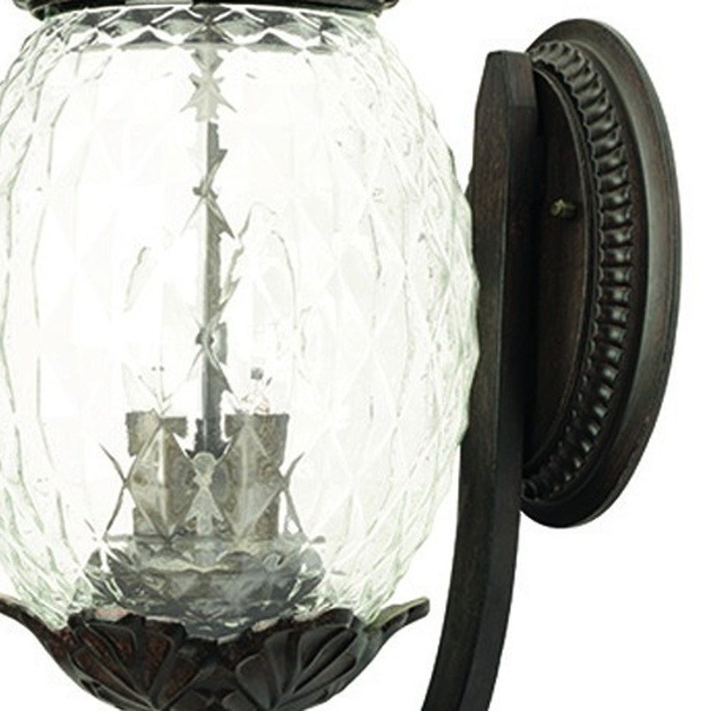 Zoomed in view of the wall plate and glass globe of the Lanai 3-Bulb Upward Outdoor Wall Light in Black Coral Finish with Pineapple Textured Glass