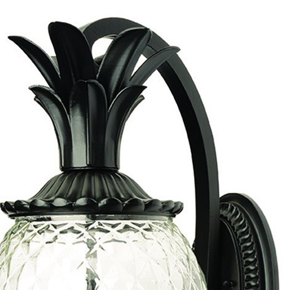 Zoomed in view of the curved arm and pineapple top of the Lanai 3-Bulb Matte Black Outdoor Wall Lantern with Pineapple Design and Textured Glass