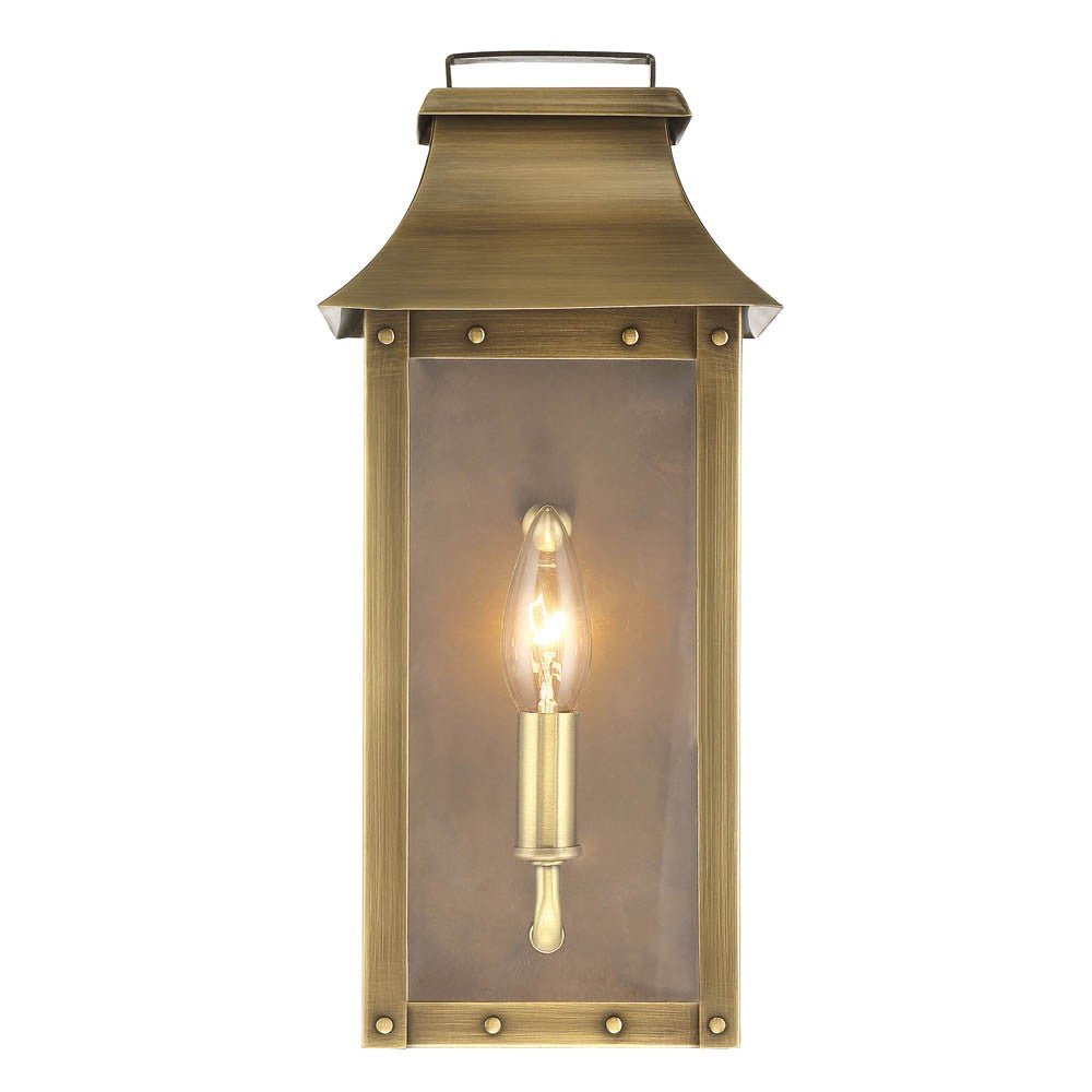 Front view of the lighted Manchester 1-Bulb Aged Brass Pocket Wall Light with clear glass and solid brass frame – outdoor lantern style wall sconce