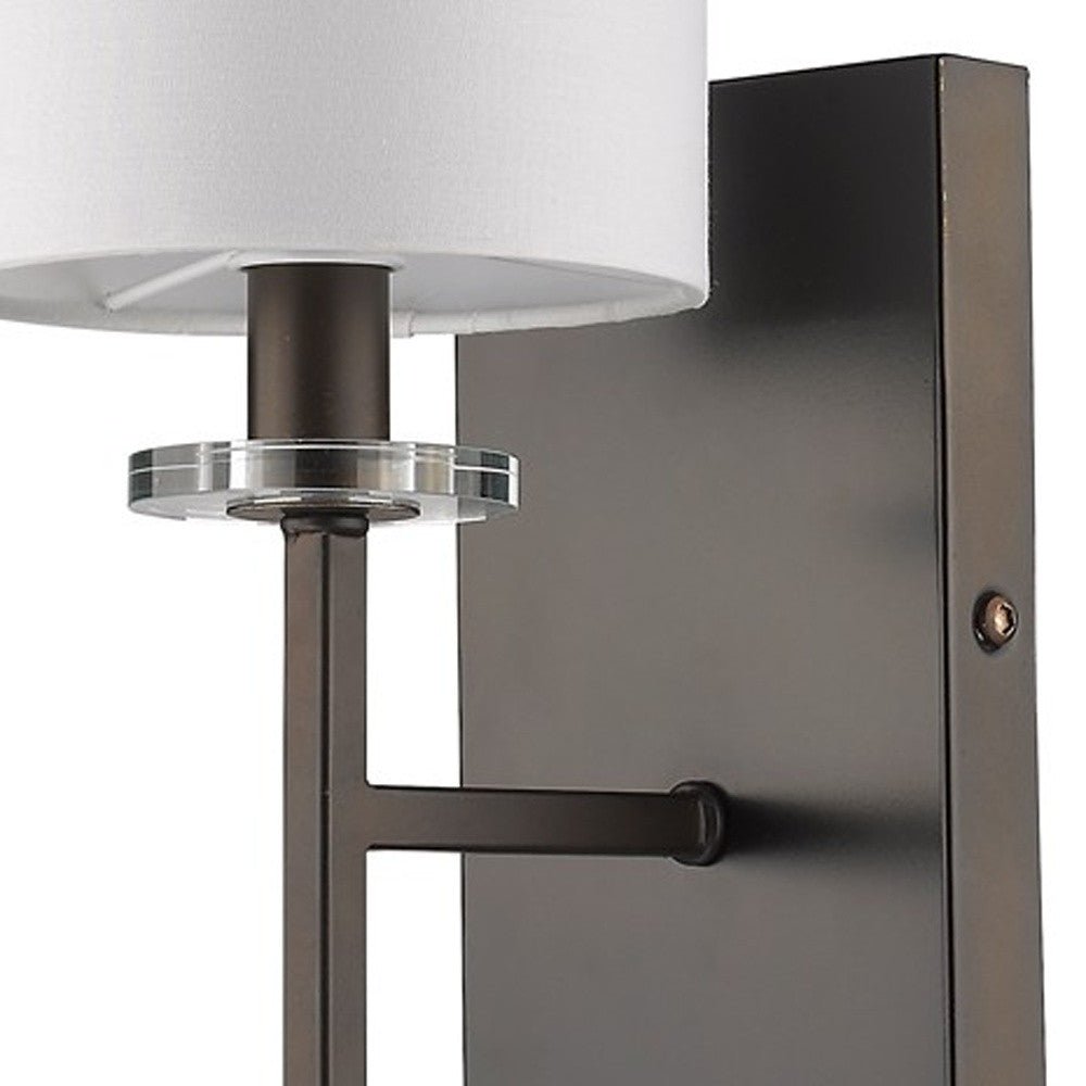 Zoomed in view of the square wall plate, angled arm, and base of the Minimalist Bronze Wall Sconce with White Fabric Shade and Crystal Bobeche Accent