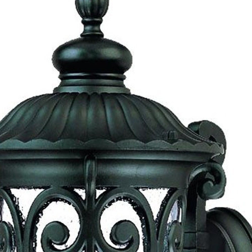 Zoomed in view of the lantern top of the Naples Matte Black Outdoor Wall Lantern with Seeded Glass and Scroll Design