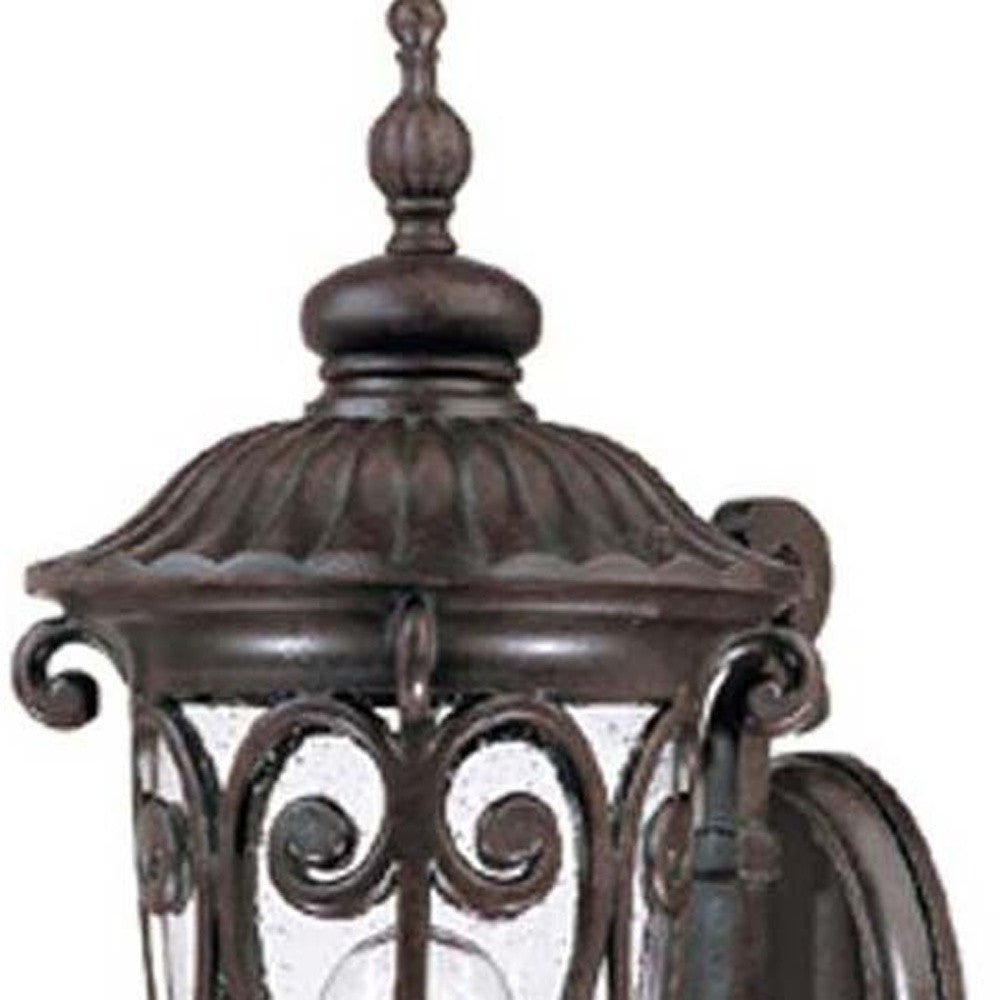 Zoomed in view of the lantern top of the marbelized mahogany outdoor wall lantern sconce with ornate cast aluminum frame and clear seeded glass for porch or entryway lighting