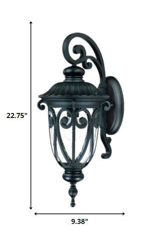 Naples matte black outdoor wall lantern with ornate scrollwork and seeded glass shade shown with dimensions of 22 point 75 inches high by 9 point 38 inches wide