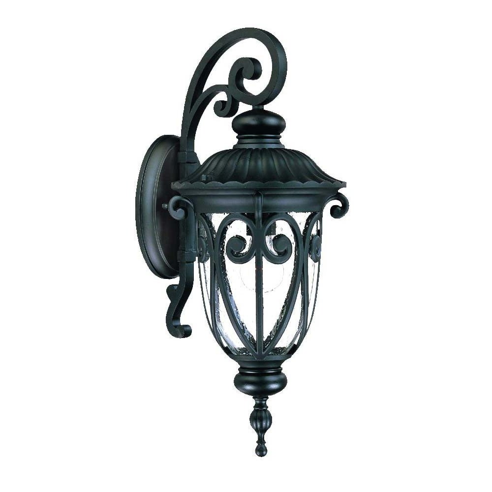 Left side angled view of the Naples matte black outdoor wall lantern with ornate scrollwork and seeded glass shade