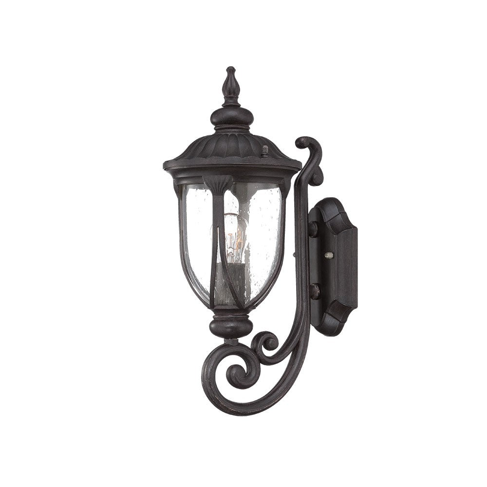 Right side angled view of the lighted Black cast aluminum outdoor glass lantern wall light with curved shield silhouette