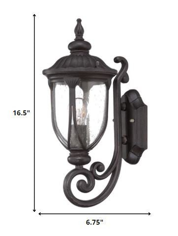 Black cast aluminum outdoor glass lantern wall light with curved shield silhouette shown with dimensions of 16 point 5 inches high by 6 point 75 inches wide