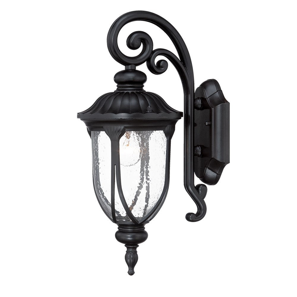 Right side angled view of he lighted Matte black cast aluminum outdoor glass lantern wall sconce with clear panels