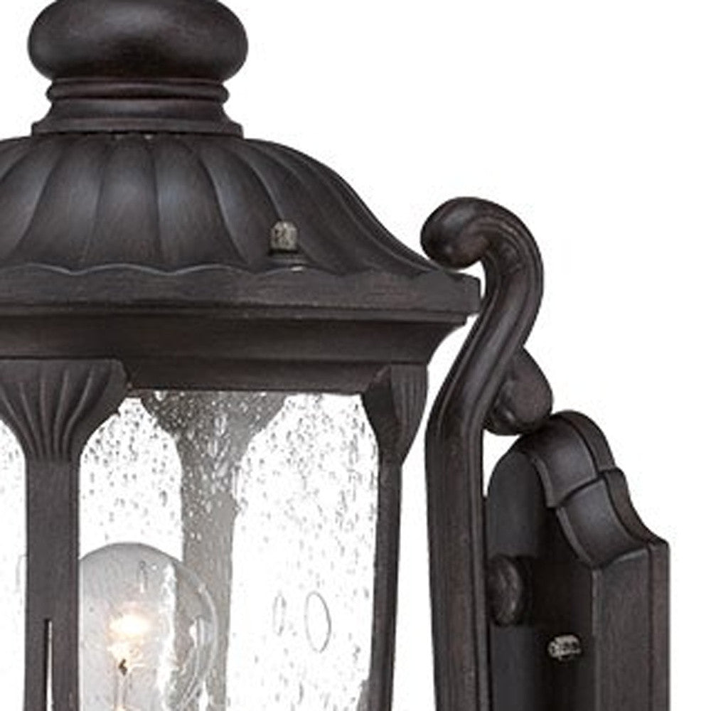 Zoomed in view of the wall plate, arm and fixture of the lighted XL black cast aluminum standing lantern outdoor wall light with clear glass panels