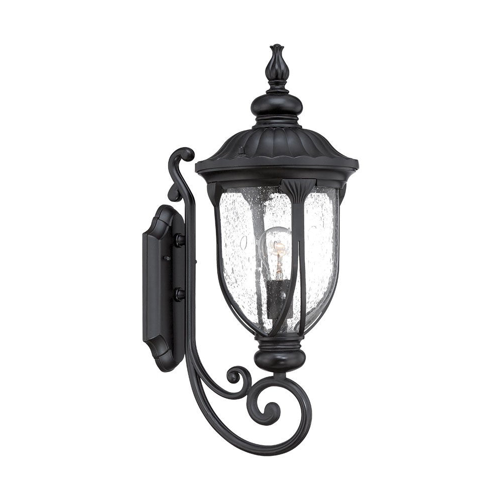 Left side angled view of the lighted XL matte black cast aluminum standing lantern outdoor wall light with clear glass panels