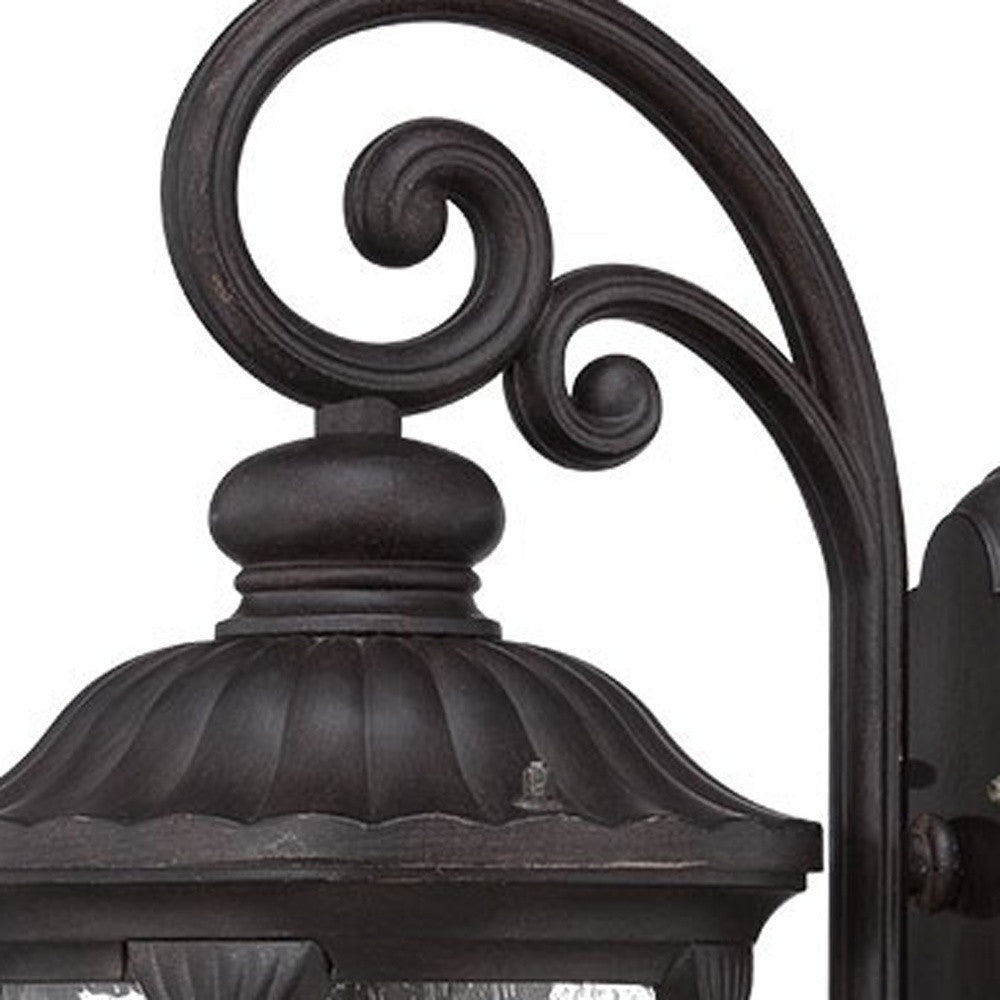 Zoomed in view of the scroll arm and lantern top of the XL black cast aluminum outdoor hanging lantern wall sconce with clear glass panels