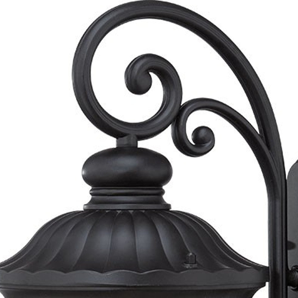 Zoomed in view of the scroll arm and fixture top of the XL matte black cast aluminum outdoor hanging lantern wall sconce with clear glass panels