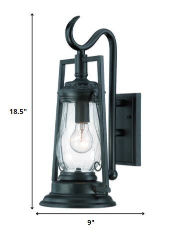 Matte black oil lamp-inspired outdoor wall light with clear glass shade shown with dimensions of 18 point 5 inches high by 9 inches wide