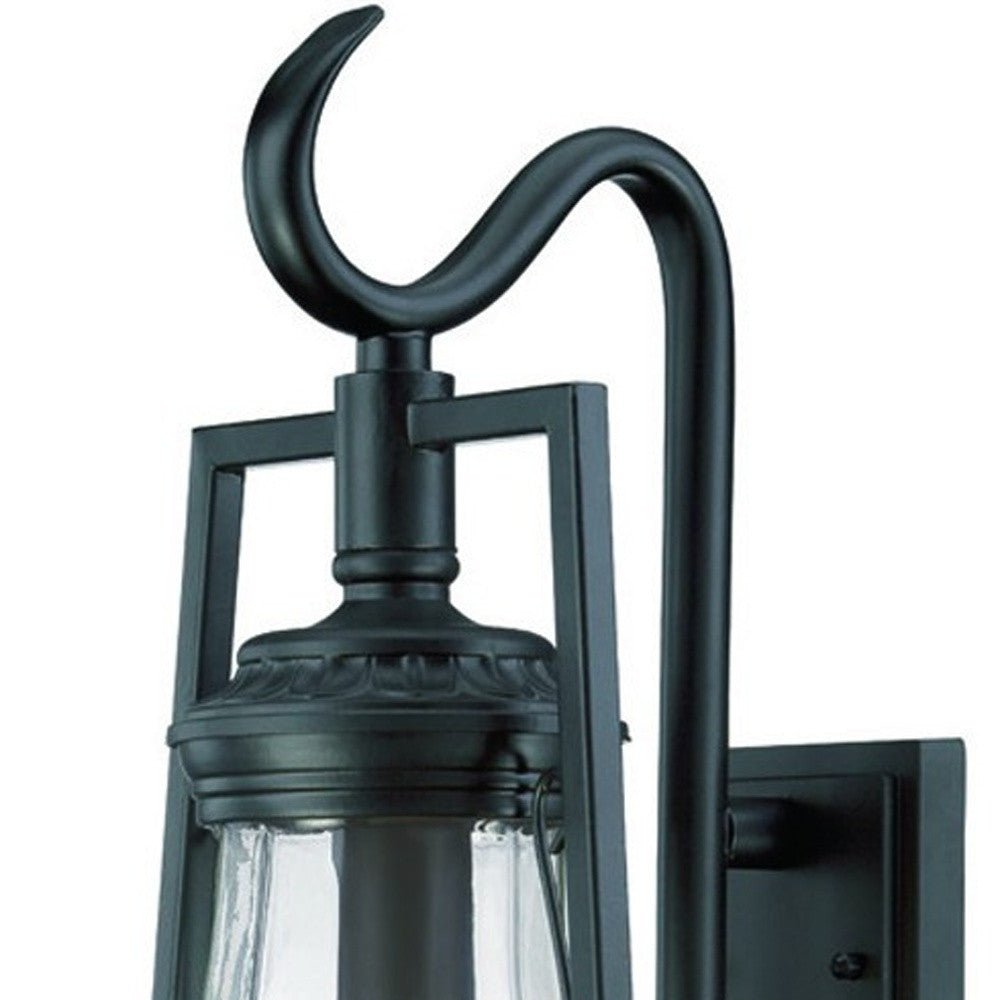 Zoomed in view of the hook arm and fixture top of the Matte black oil lamp-inspired outdoor wall light with clear glass shade
