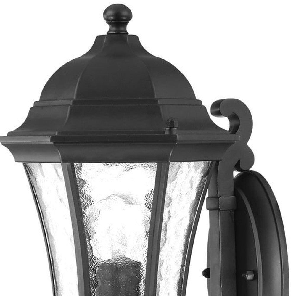 Zoomed in view of the fixture top and glass shade Matte black tapered outdoor lantern wall light with hammered glass panels