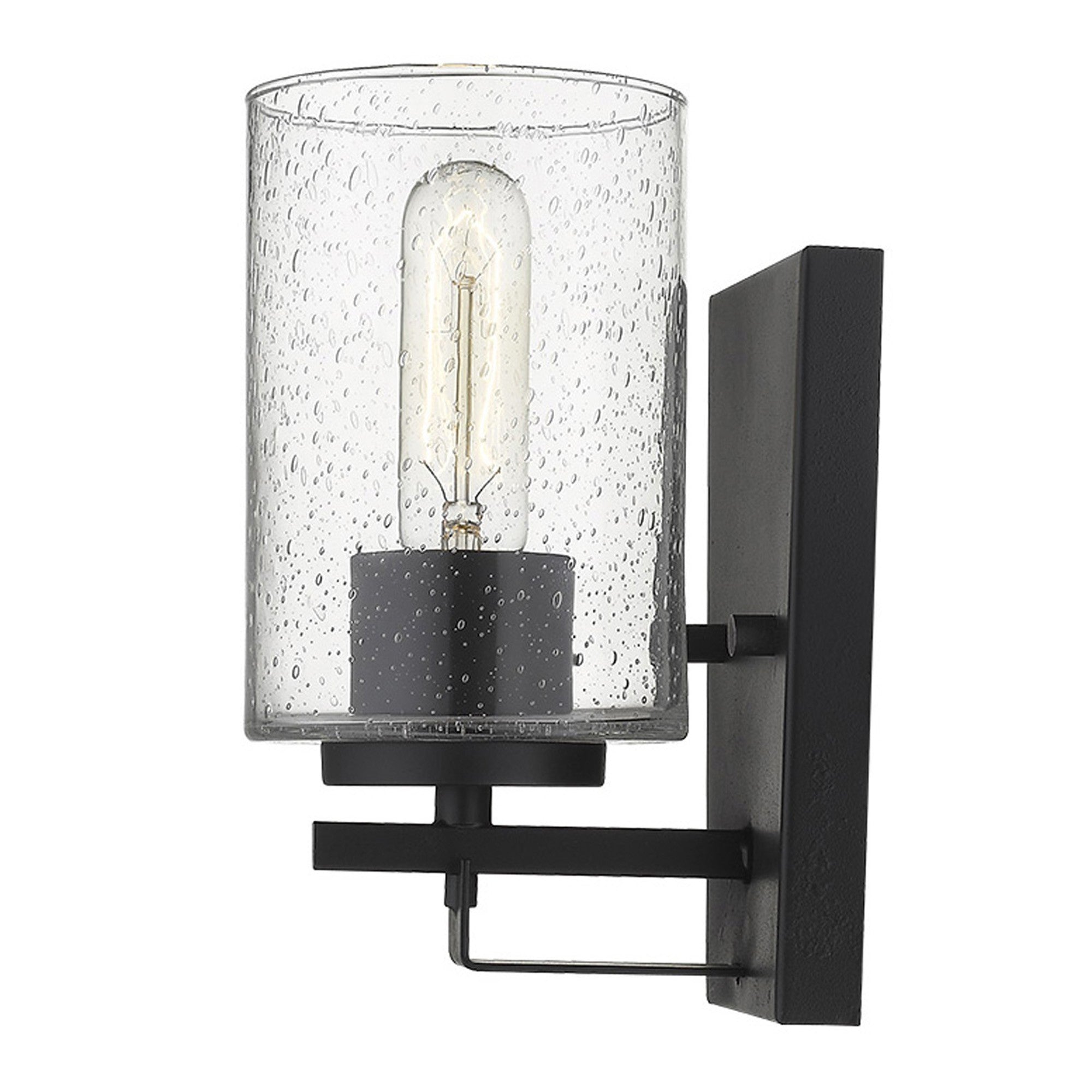 Side view of A lighted black metal and textured glass wall sconce with a clear glass shade and a warm light bulb visible, mounted on a black wall bracket.