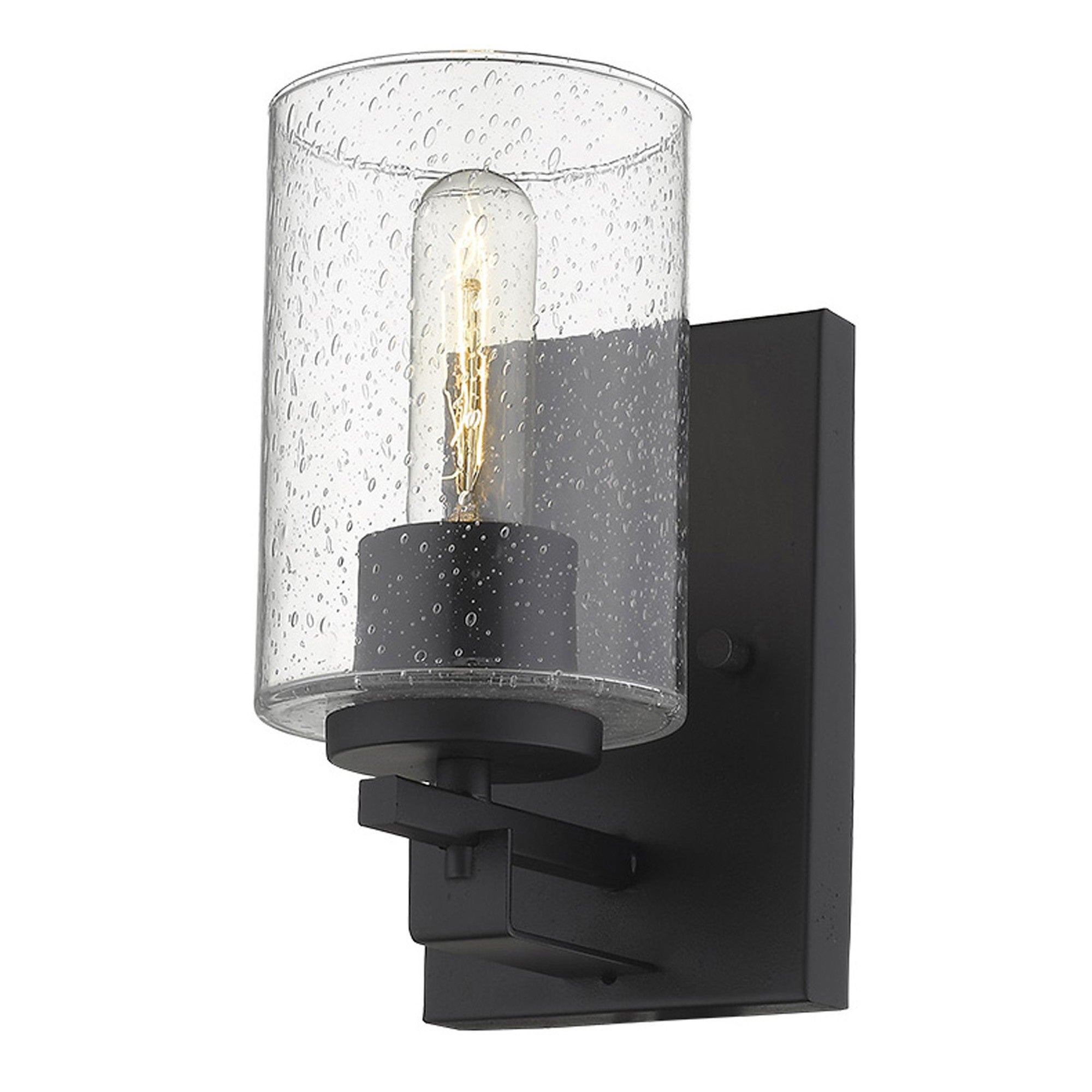 Right side bottom up view of A lighted  black metal and textured glass wall sconce with a clear glass shade and a warm light bulb visible, mounted on a black wall bracket.