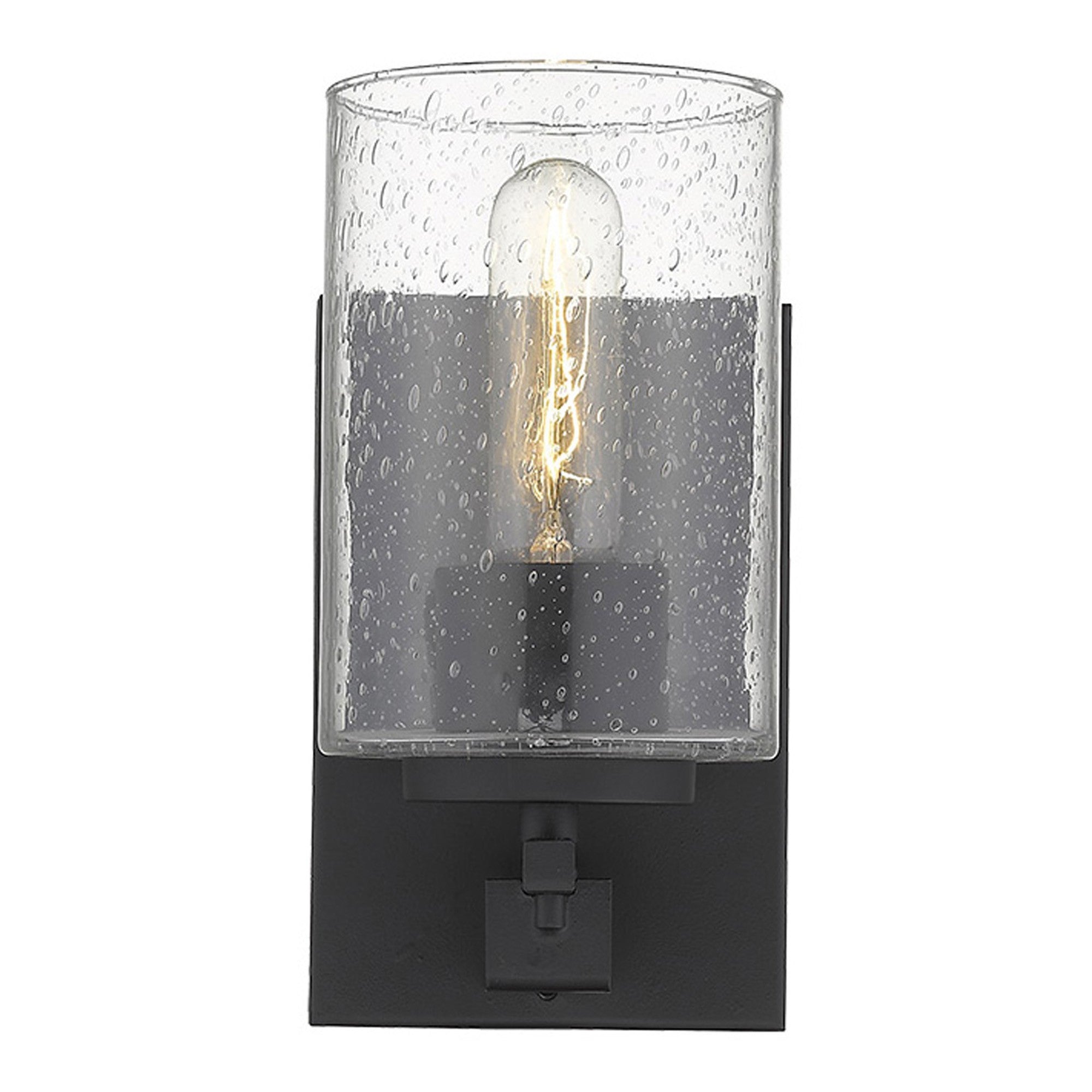 Front view of A lighted black metal and textured glass wall sconce with a clear glass shade and a warm light bulb visible, mounted on a black wall bracket.