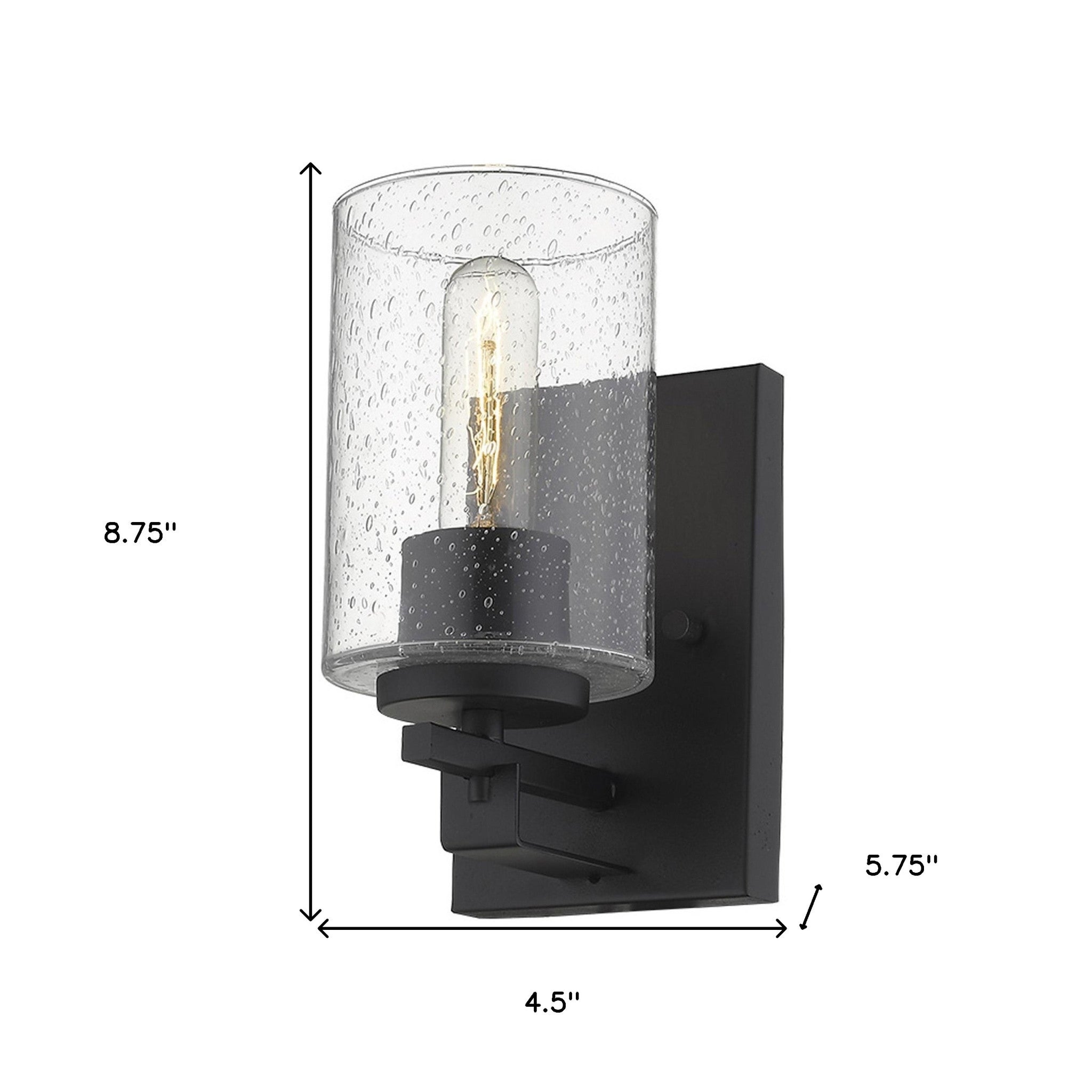 A black metal and textured glass wall sconce with a clear glass shade and a warm light bulb visible, mounted on a black wall bracket shown with dimensions of 8 point 75 inches high by 4 point 5 inches wide by 5 point 75 inches deep