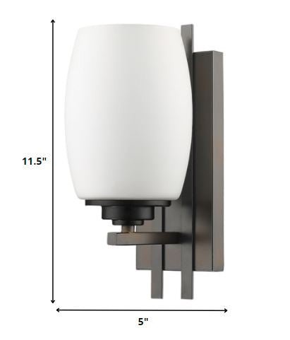 Geometric bronze wall sconce with frosted glass shade for modern indoor lighting in hallways, bedrooms, and living spaces shown with dimensions of 11 point 5 inches high by five inches wide