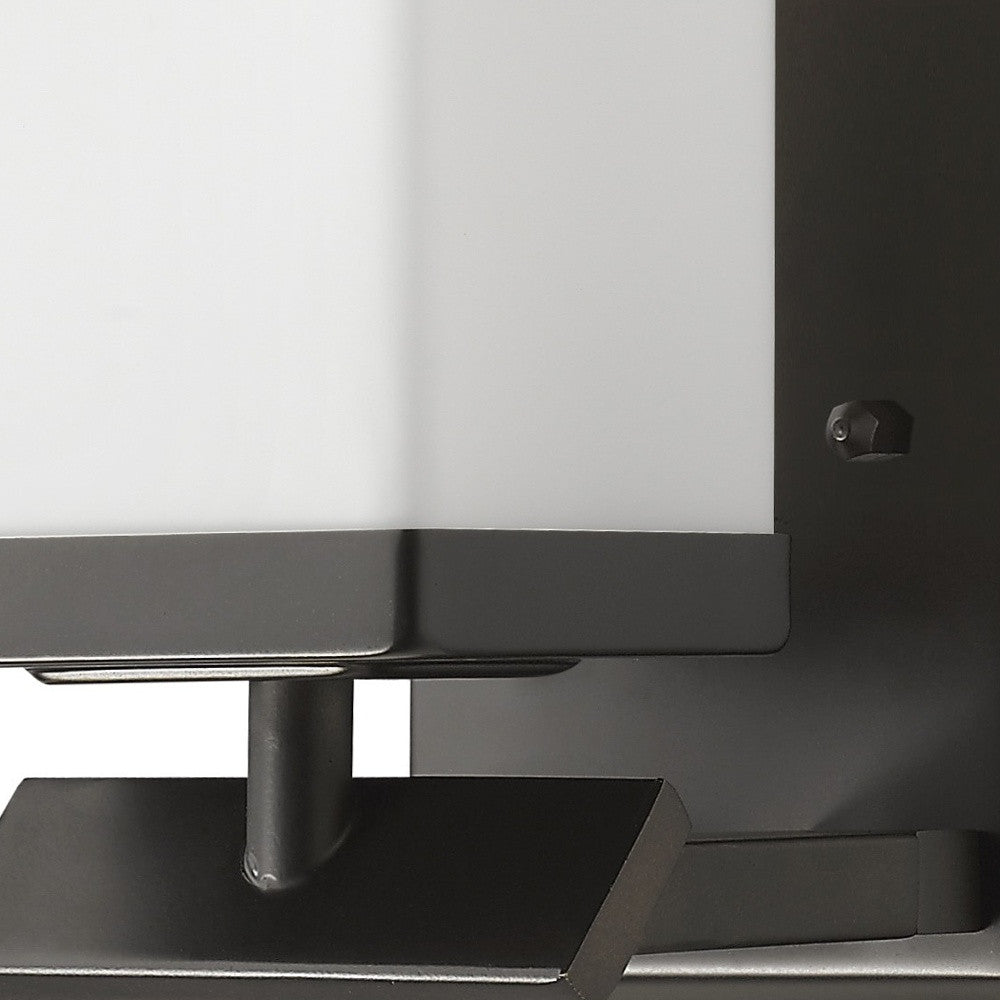 Zoomed in view of the arm base and partial shade of the One-light bronze wall sconce with cube frosted glass and rectangular backplate