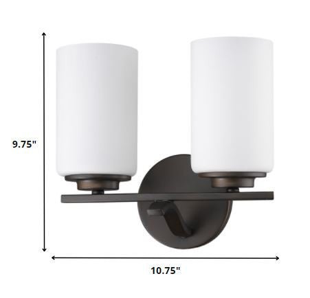 Two-light bronze wall sconce with cylindrical frosted glass shades and round base plate shown with dimensions of nine point seven five inches high by ten point seven five inches wide