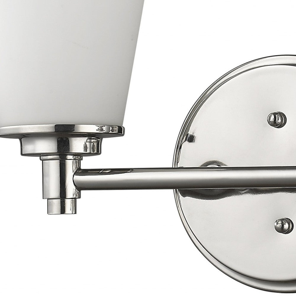 Zoomed in view of the wall plate, arm and partial glass shade of the Two-light silver wall fixture with frosted glass shades and round backplate