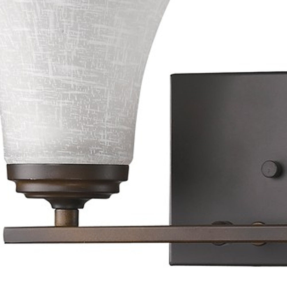 Zoomed in view of the wall plate, arm and glass shade of the Two-light bronze wall fixture with tapered textured white glass shades and rectangular backplate