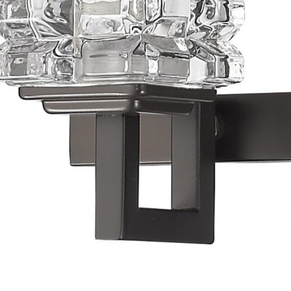 Zoomed in view of the partial shade and arm on one of the Coralie Three-light bronze wall vanity fixture with stacked clear crystal cube shades