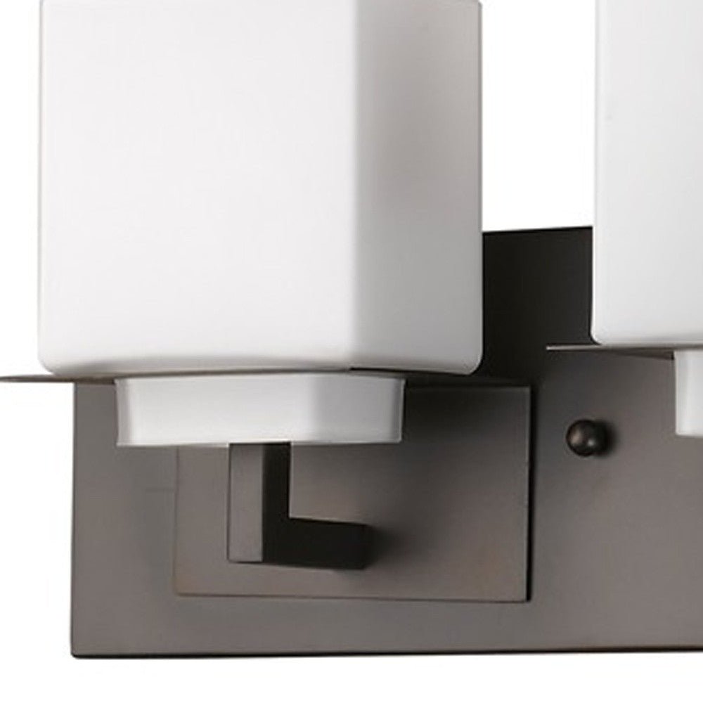 Close up view of the wall plate and arm on one of the Rampart Oil-rubbed bronze three-light vanity fixture with modern square frosted glass shade