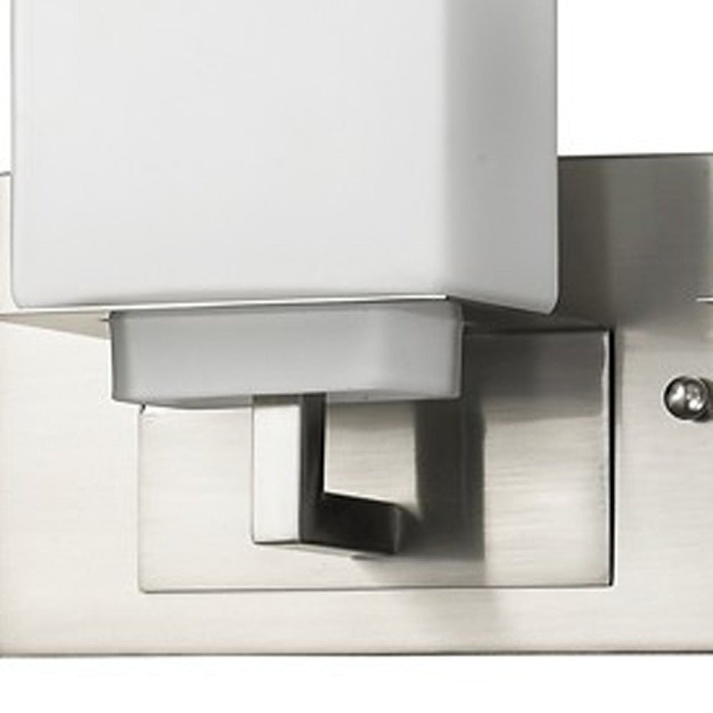 Close up view of the wall plate and arm on one of the Brushed nickel three-light vanity fixture with square frosted glass shade