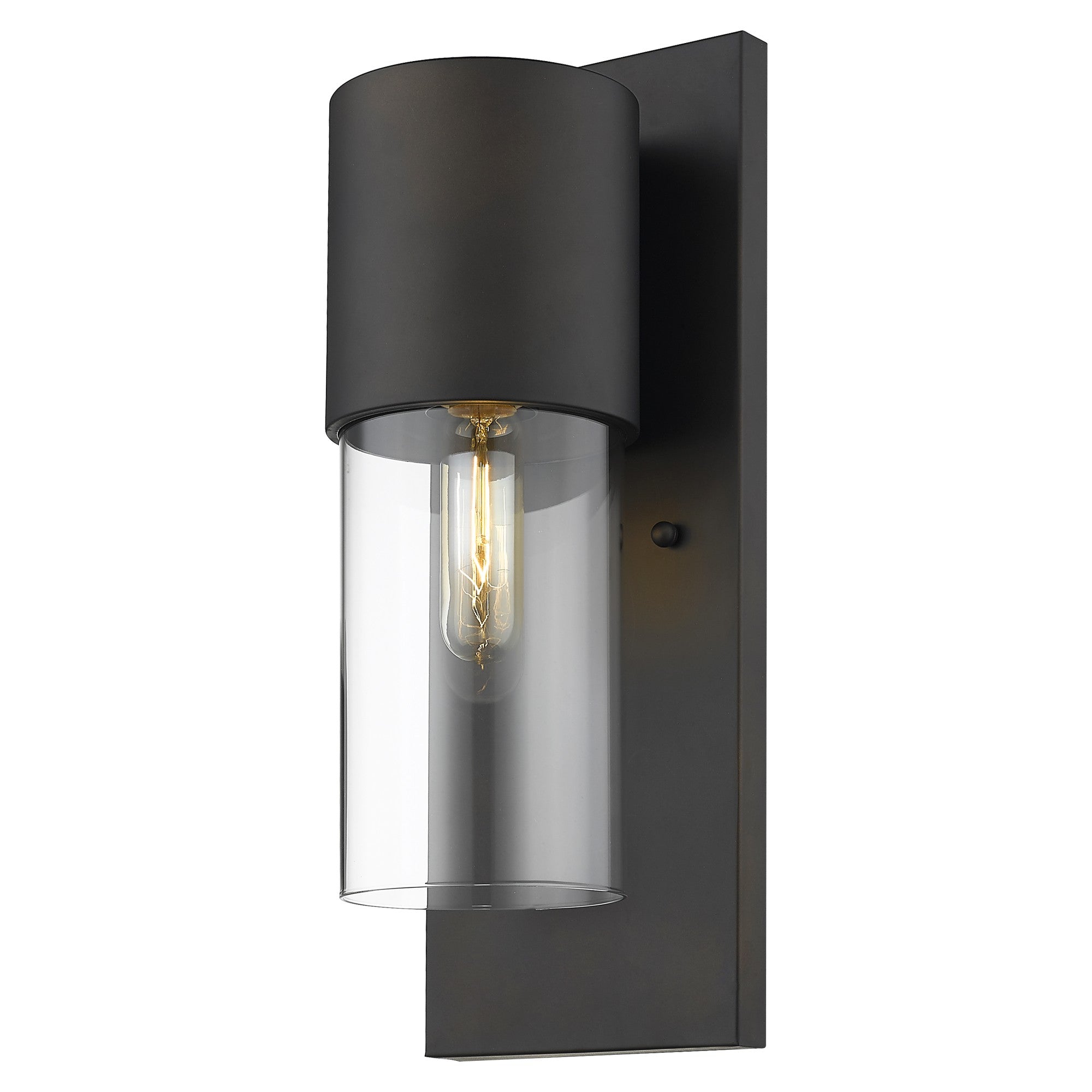 Modern bronze wall sconce lit with clear cylindrical glass shade and vertical mounting plate