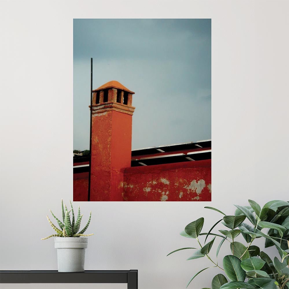48 inch wall decal of a red brick Mexican building with a chimney installed on a white wall with plants in the foreground.