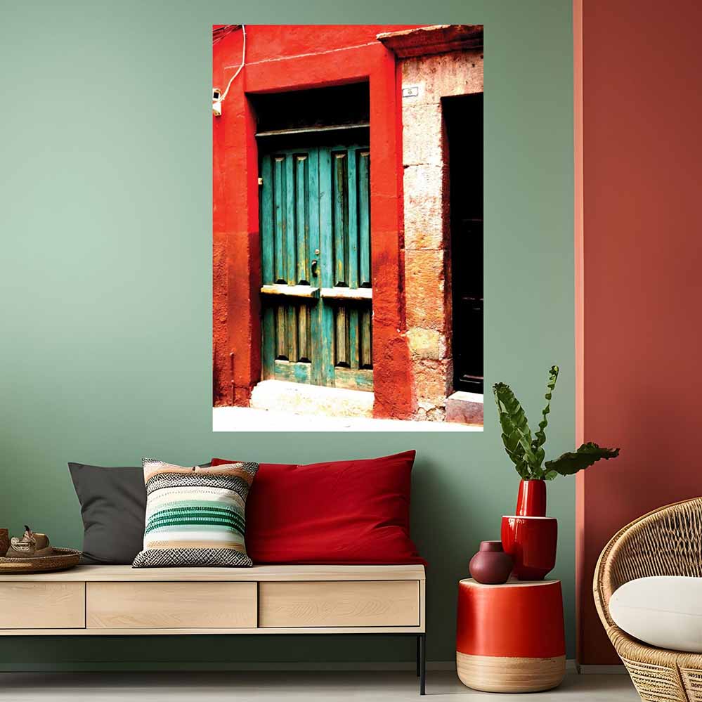 48 inch poster of a red framed green door of a Mexican home displayed on a wall above a wooden bench with pillows